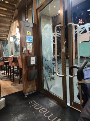 Two glass doors from the inside of the restaurant with handles on both sides. The door is a push for entry and pull for exit.