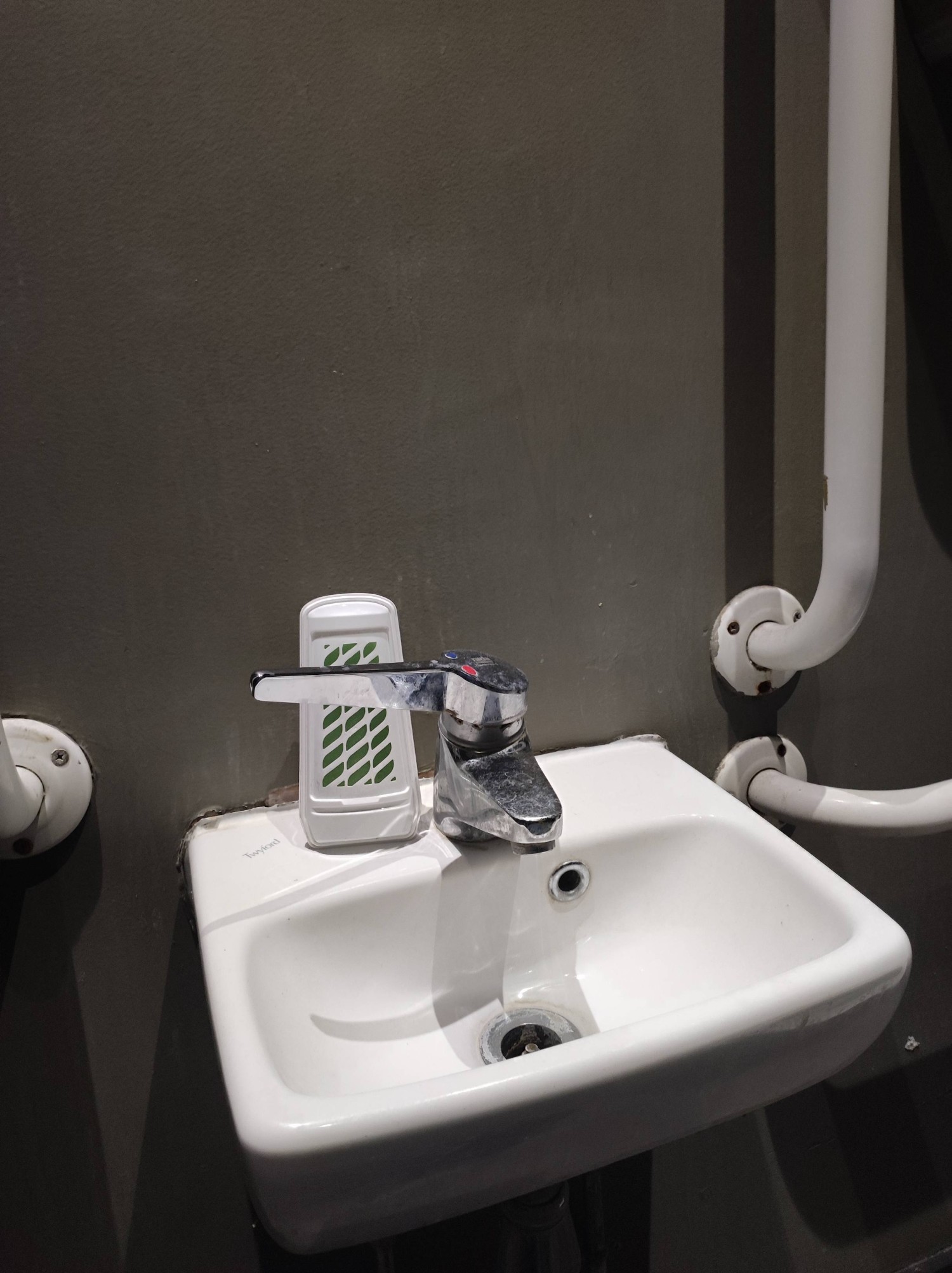 Low level sink with no soap, that wobbles while being used due to poor attachment to the wall.