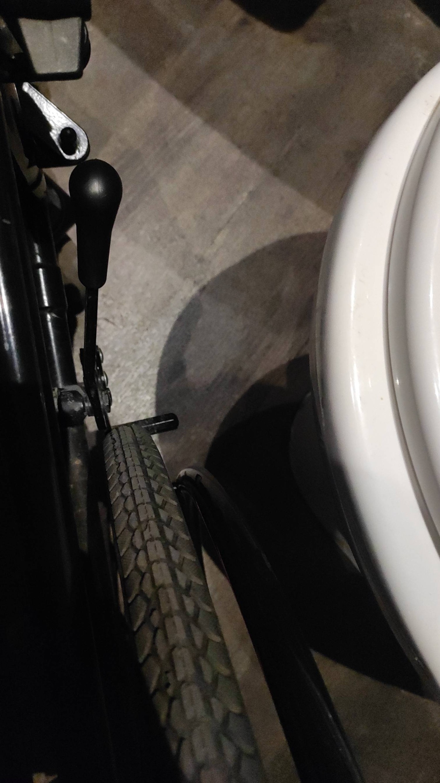 Large gap between wheelchair wheels and toilet, showing transfer difficulties due to the table blocking the area