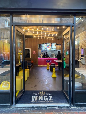 Glass doors with black frame. Push in center to open.
