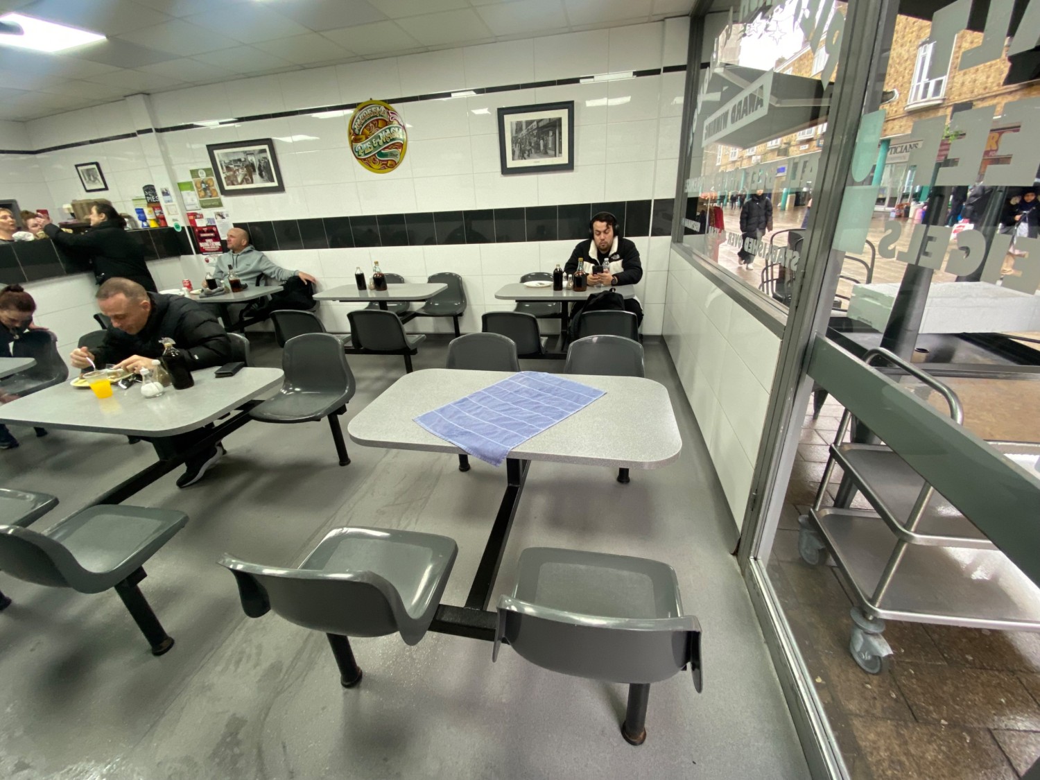 From entrance, facing right. Rows of tables and chairs ahead and on left.
