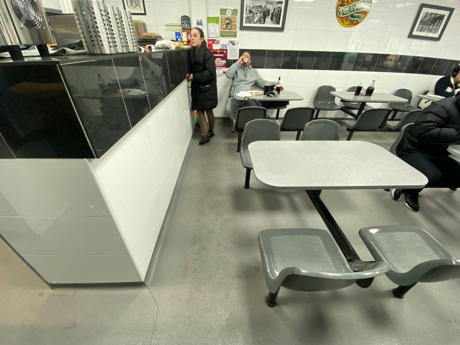 From left end of counter, facing right. Counter along left. Tables and chairs spread on right.