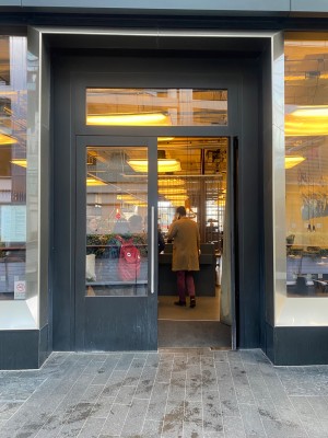 Glass doors ahead with black doorframe. Push silver handles in centre to open.