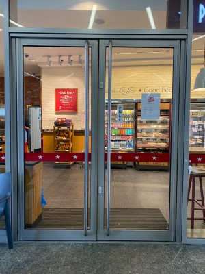 Double glass door with grey doorframe. Handles in the centre. Pull to open.