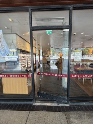 Glass door with metal handle on left. Push to open.