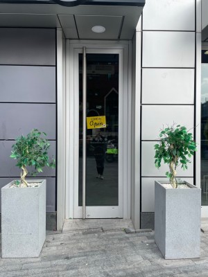 Glass door with silver metal frame, push from left to open.