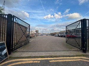 From pavement facing straight at double gates. Push from centre to open.