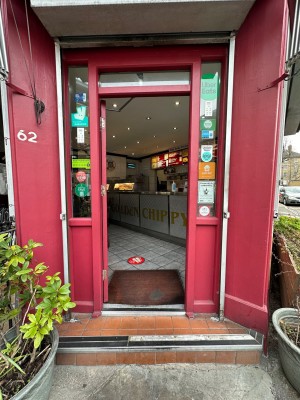 Red and glass panelled entrance door. Silver handle towards right of door. Push to open.