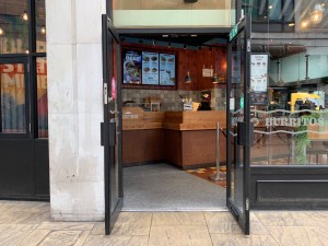 Glass doors with black frame and black handles in centre. Pull to open.