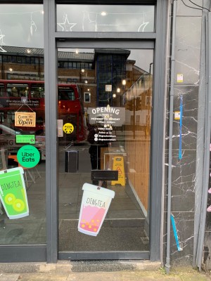 Glass door with grey metal frame ahead. Push from handle on left to open.