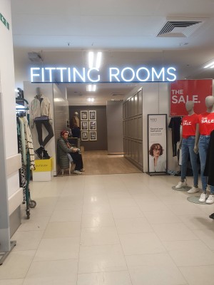 Fitting rooms entrance on the ground floor in Womenswear. 
The entrance is open with no doors and wide enough for two wheelchairs to pass each other.