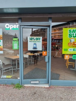 Glass door with grey frame ahead. Push on right.