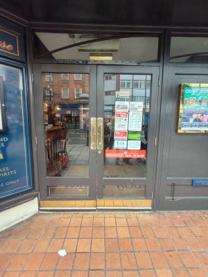Facing front door. Grey framed double glass doors leading to main area. Push golden handle in centre to open.