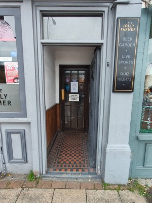 Facing grey door leading to door to entrance. Push handle on left to open. Doorbell to the right.