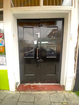 From street facing entrance. Black double door ahead. Push handles from centre to open inwards.