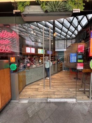 Glass doors with silver metal handles in middle. Pull to open.