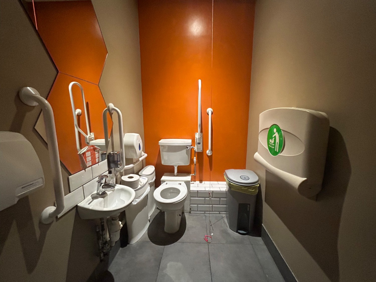 From doorway, facing straight. Baby change to right. Toilet to back left. Pull cord to right of toilet. Sink to left.