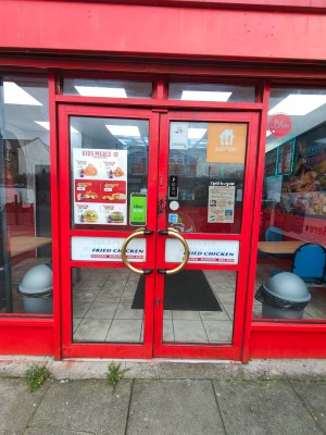 Facing entrance door. Red framed double glass door leading to main area. Push golden handle in centre to open.