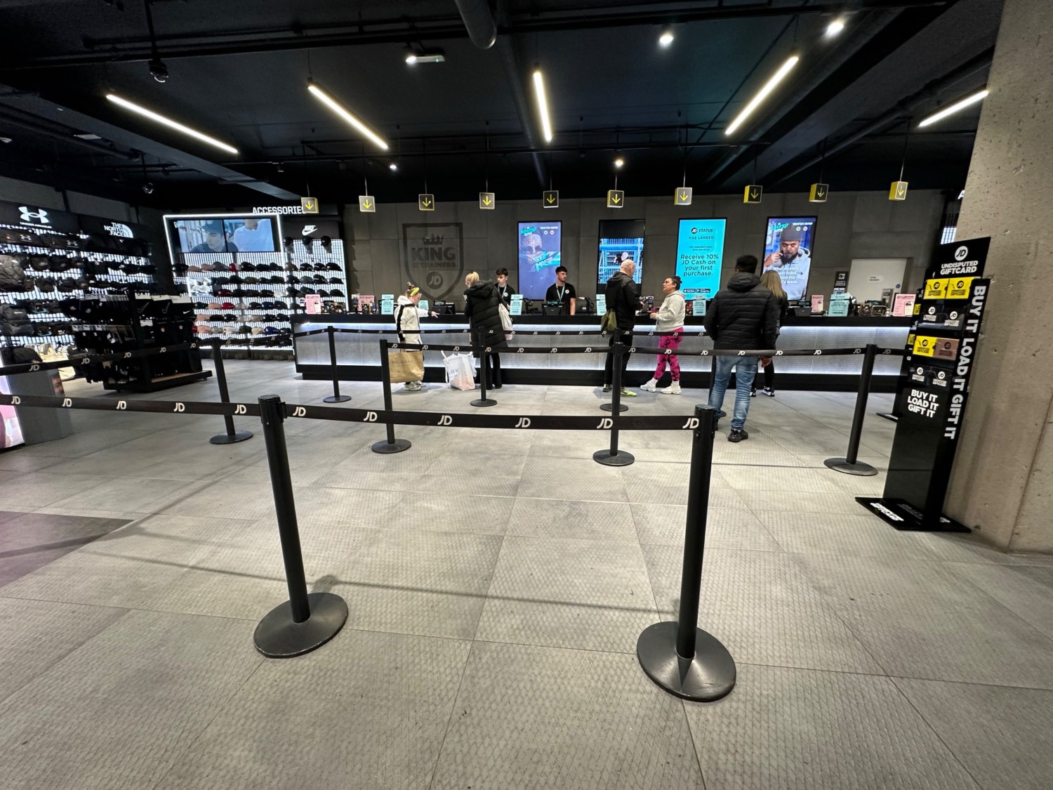 From end of divider facing left. Path to the right leads around dividers to the tills evenly spaced along back wall ahead.