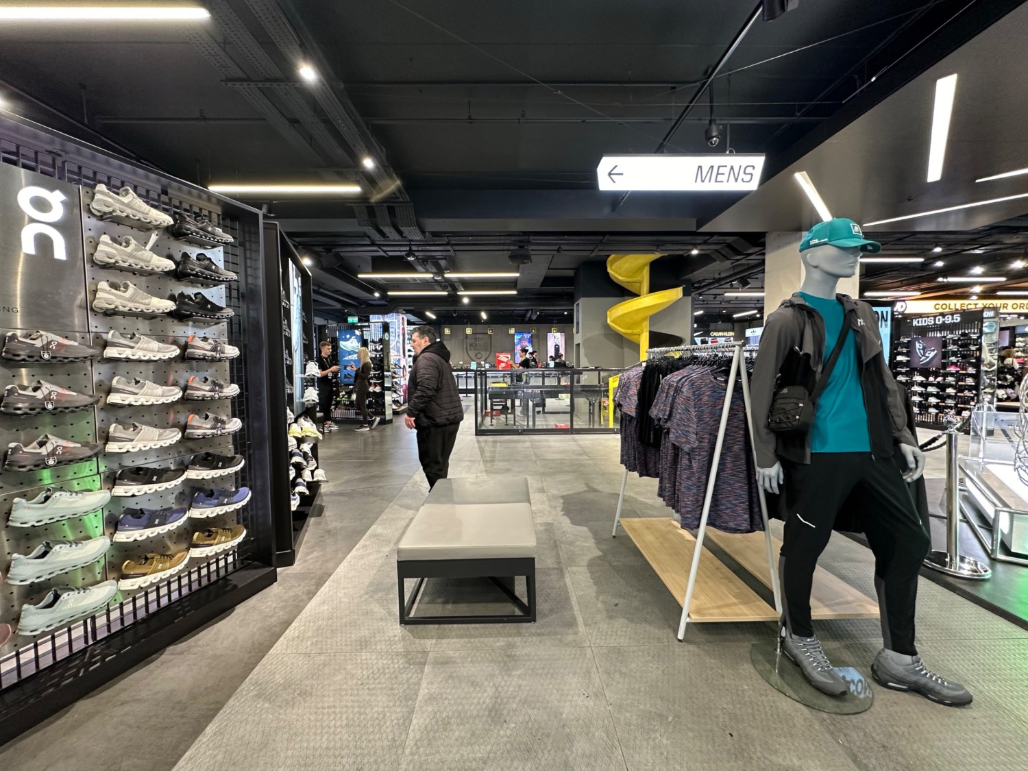 From after clothes rack facing right. Bench in centre of path ahead. Shoe rack along left wall.