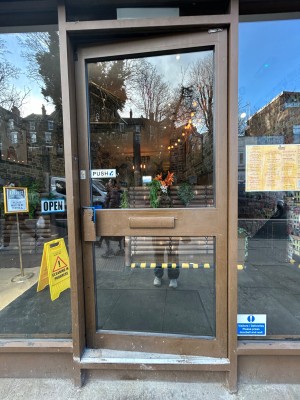 Single preceding glass door with brown frame. Push from left to open.