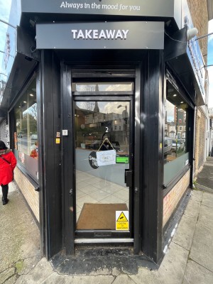 Black framed door. Push open via handle on right.
