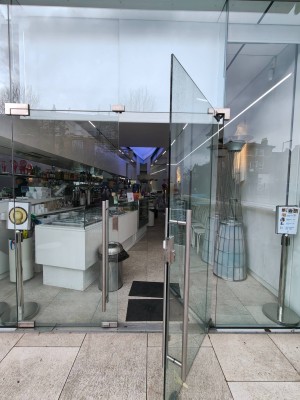 Single glass door. Pull silver grab rail on left to open.