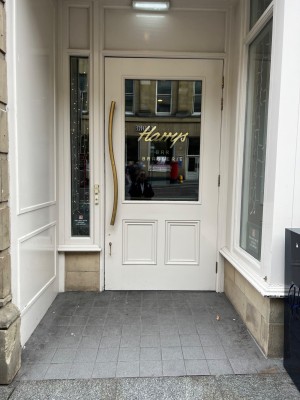 First entrance door. Slight ramp to enter with doorbell to call for assistance as door is locked. Door opens outwards from left to right.
