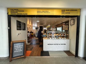 Large upwards sliding door with black frame, always kept open. A-frame sign on left side of opening.