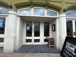 White wide open archway preceding main doorway.