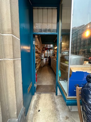 Glass door with blue frame. Push handle on right to open.