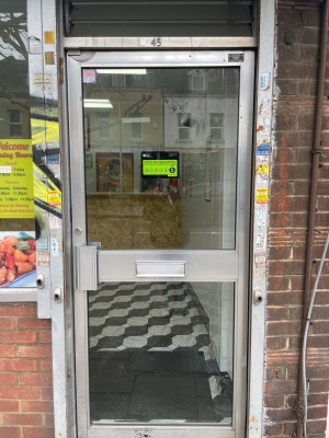 Silver glass door with handle on left, push to open.