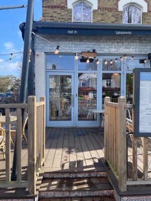 Steps leading up to the landing, outdoor seating, and main entrance door.