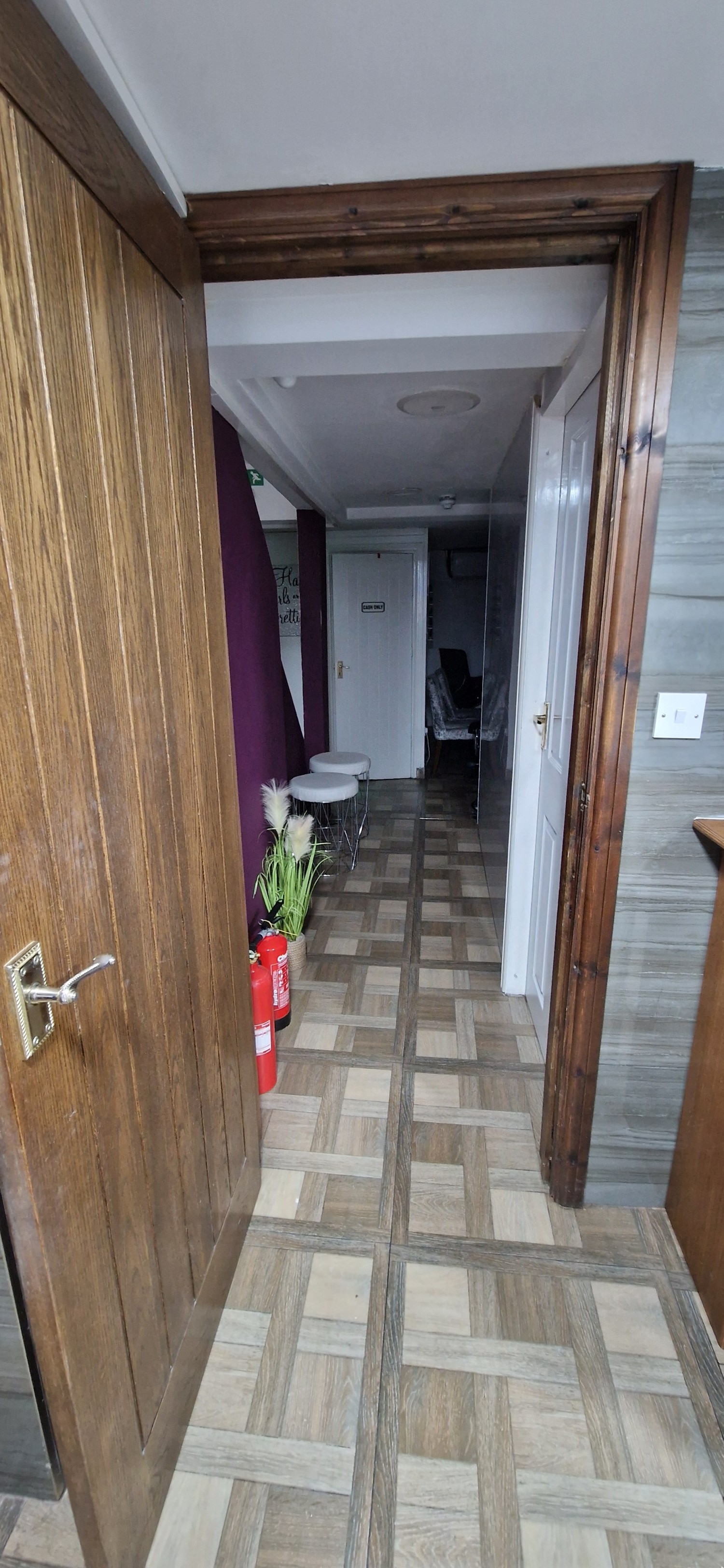Corridor from toilet to stairs. Small step near stairs. Even floor and standard width corridor