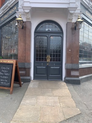 Glass door with black, wooden frame. Pull from golden handles from middle to open.