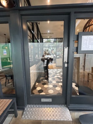 Single grey framed glass door. Push vertical silver handle on right to open.