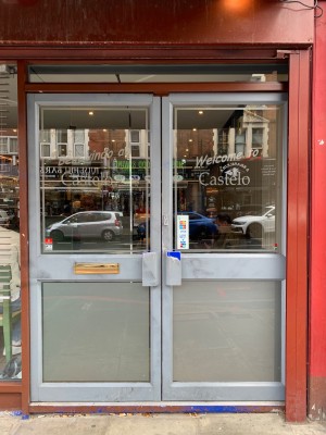 Double glass doors with metal frames ahead. Push from handles in centre to open.