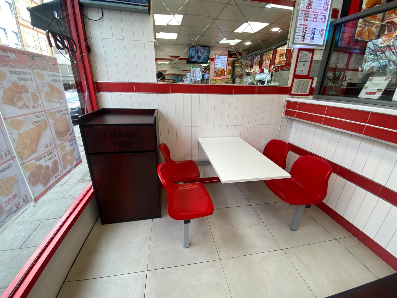 From entrance, facing left. Table and chairs in front. Counter on right.