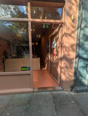 Pink frame door in front. Door knob on left. Push to open.