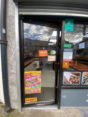 Glass door, with black doorframe. Handle on right. Push to open.