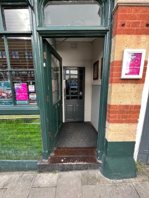 Green framed glass panelled door. Push from right side to open.