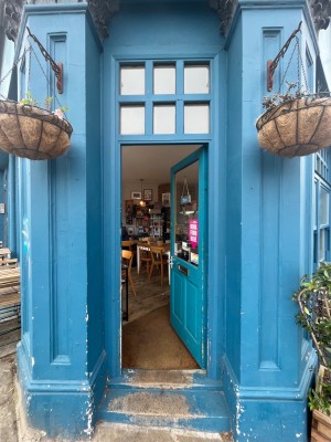 Blue wooden glass door ahead. Push handle on left to open.