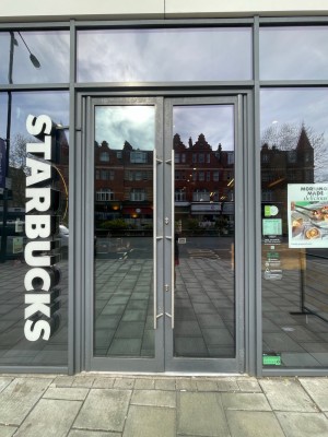 Grey framed glass door with long silver metal handle in centre. Push or pull to open.