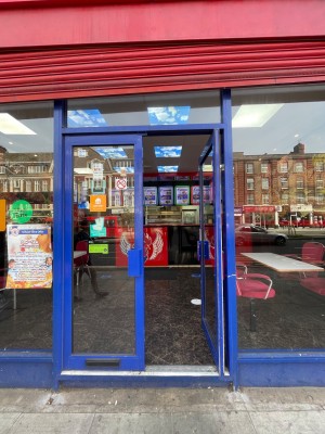 Blue framed glass double door with blue handle in centre, push to open.