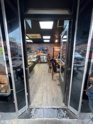 Black framed glass door. Push from left side to open.
