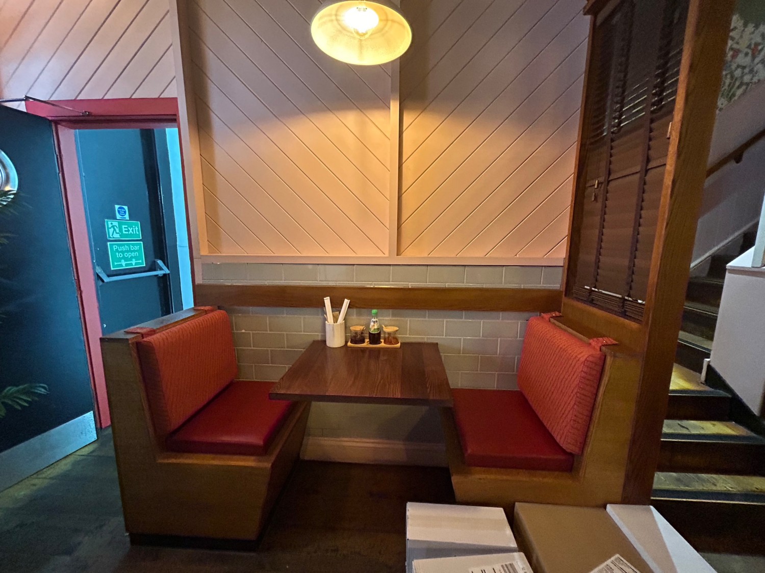 From middle of left pathway, facing left. Booth ahead. Stairs to upstairs seating on right.