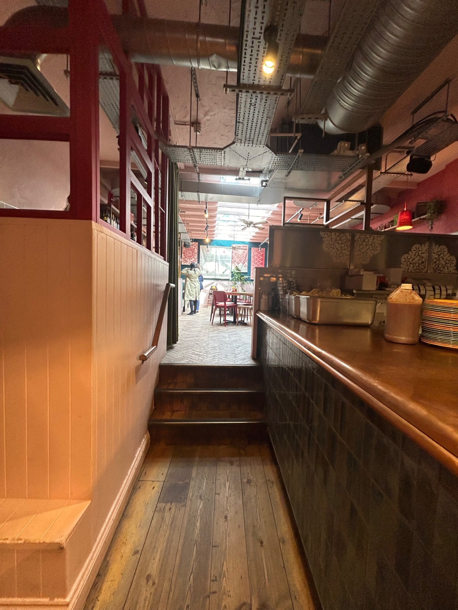 From further along pathway, facing straight. Steps up to back area ahead. Counter ends on right.