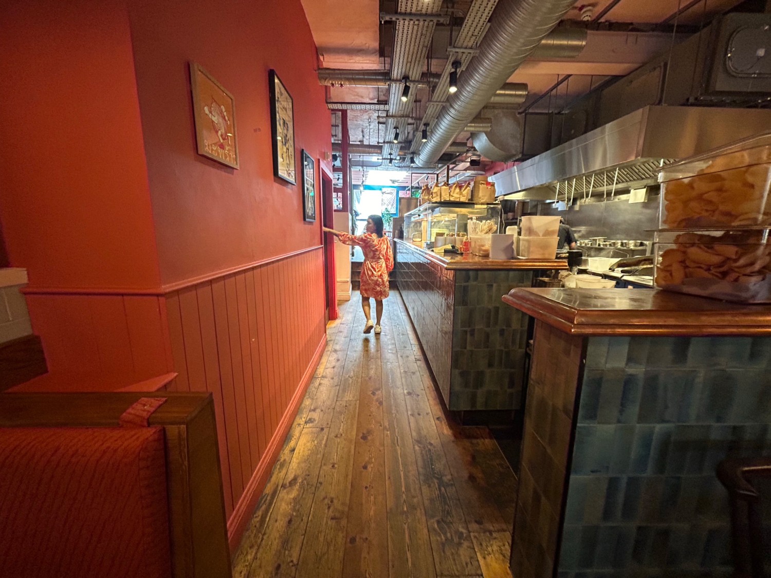 From start of kitchen counter, facing straight. Counter along right wall. Path ahead leads to toilet further ahead on left wall, and back area.
