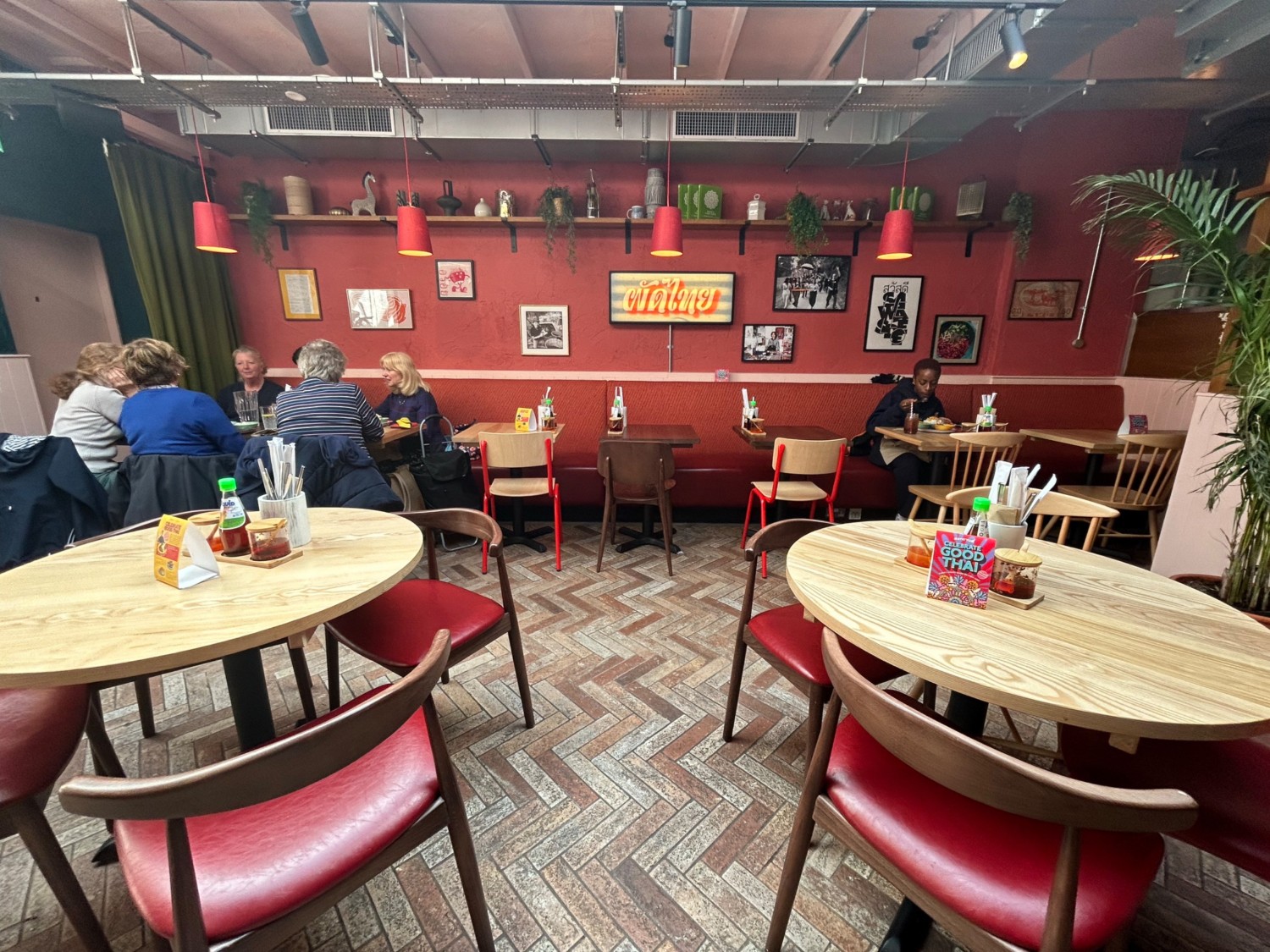 From start of booths, facing right. Tables and chairs on left and right. Half booths along back wall.