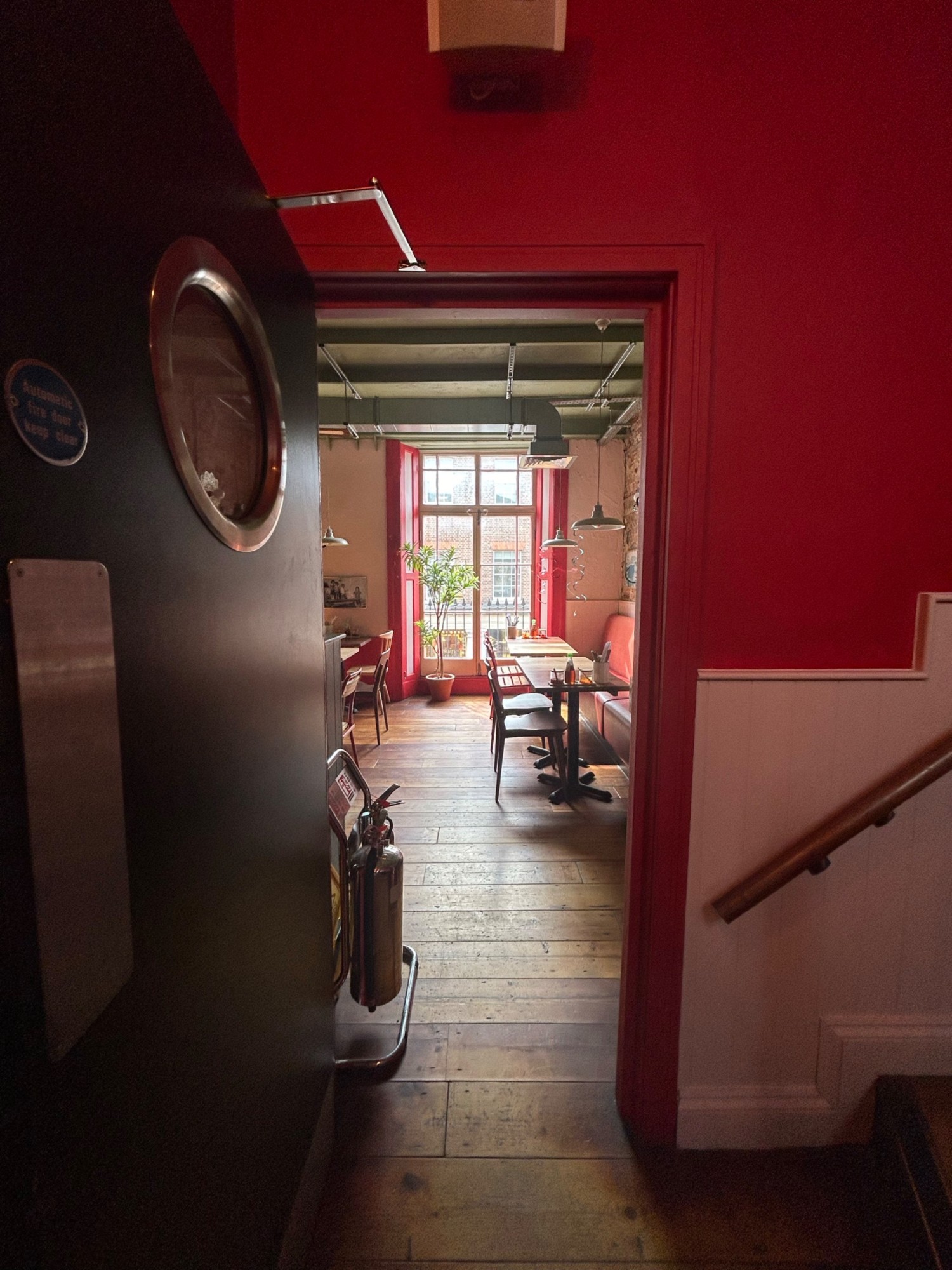 From top of stairs, facing straight. Single black wooden door ahead. Pull from right to open.